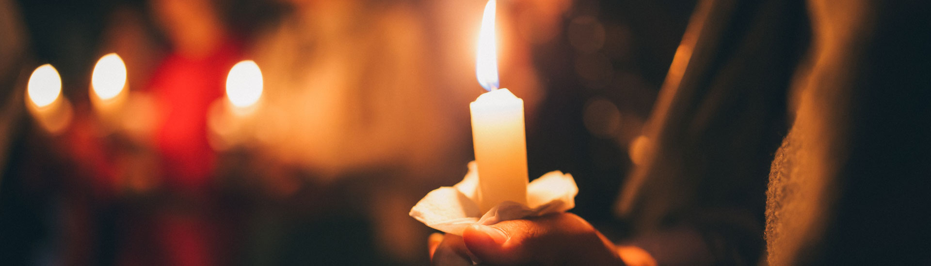 A Girl Holds a Lighted Candle in her Hands